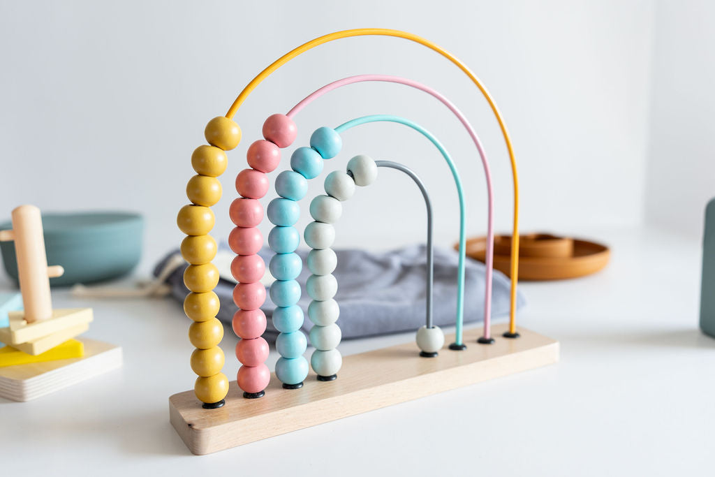 Colorful wooden abacus on a white surface with a neutral background